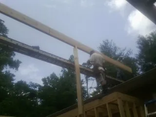 Carpenter setting a ridge beam over a new addition frame — Ice Dam Removal by Roofing Brothers in Conyers