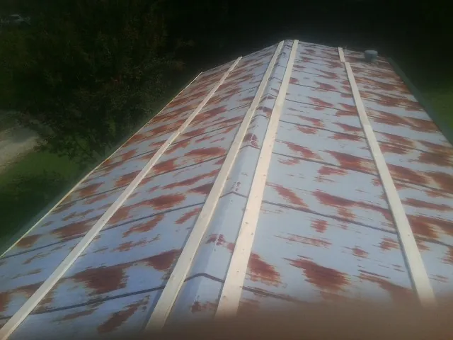 Rusted metal roof panels with new wood purlins before replacement — Storm Damage Roof Repair in Conyers by Roofing Brothers