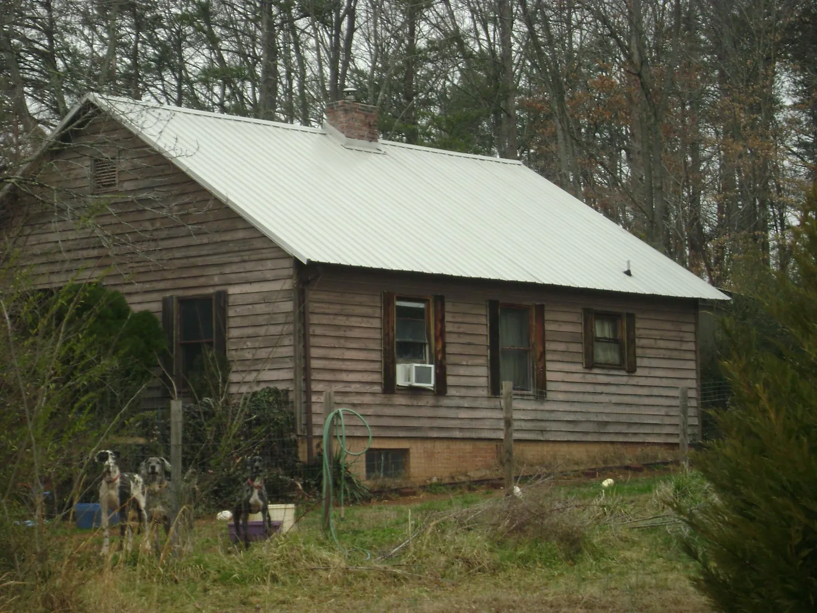 White metal roof on an old wood sided farmhouse, from a Asphalt Shingle Roof Repair job in Conyers